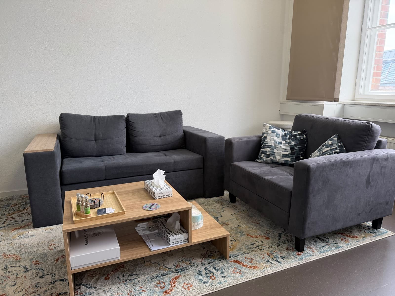 Gemütliche Sitzecke mit zwei Sofas und Couchtisch in der kraftspuren Physiotherapie