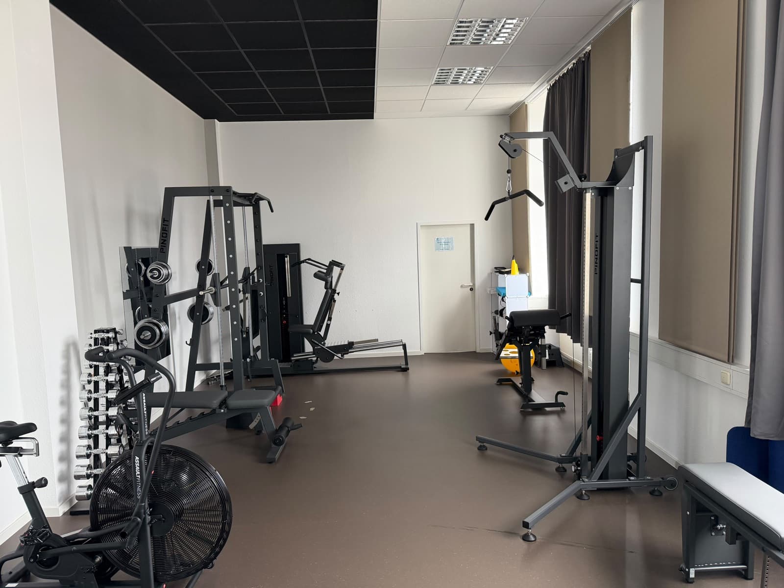 Sportraum mit Trainingsgeräten, Hanteln und Fahrradergometer
