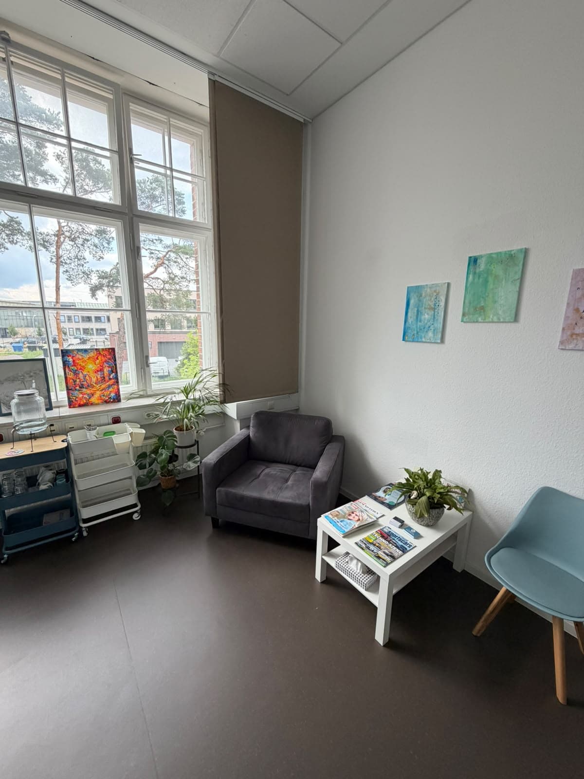 Warteecke mit Sessel und Kunst an der Wand